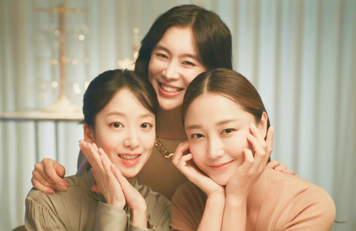 three young women grouped together smiling looking at camera