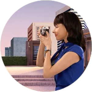 Woman outdoors taking a photo with a camera in front of modern city buildings
